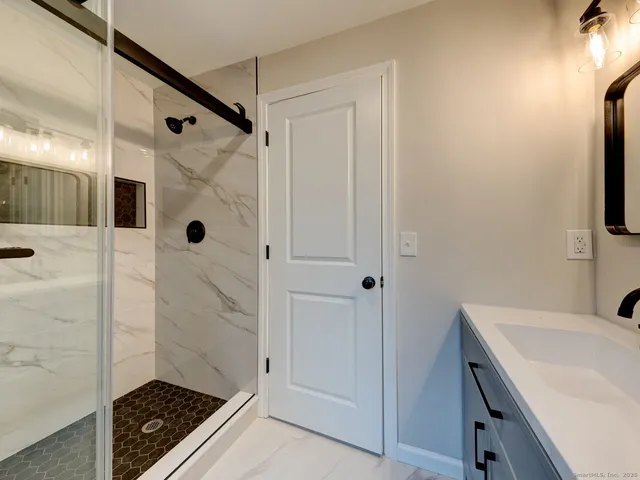 a bathroom with a sink a shower and a mirror