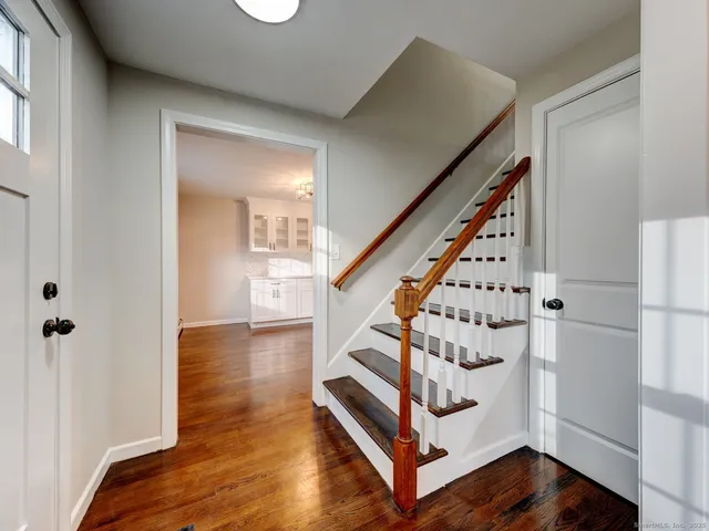 a view of an entryway with wooden floor and staircase