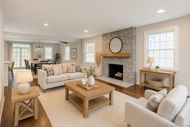 a living room with furniture a fireplace a rug and a window