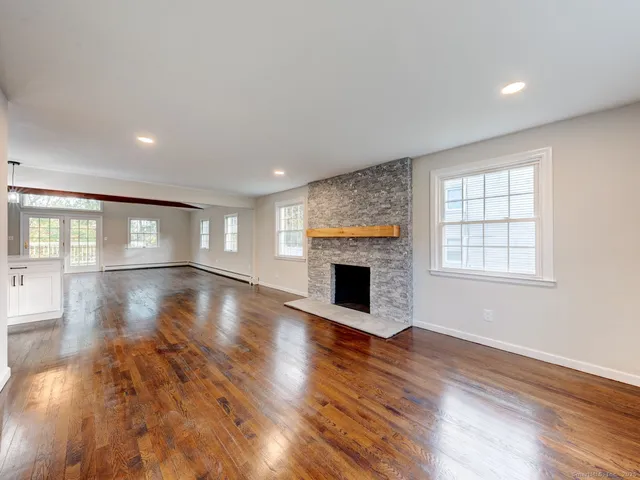 a view of empty room with wooden floor and fireplace