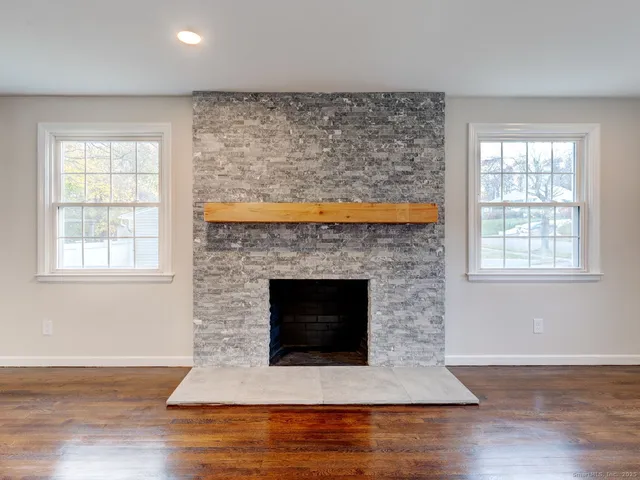 a living room with a fireplace and a floor to ceiling window
