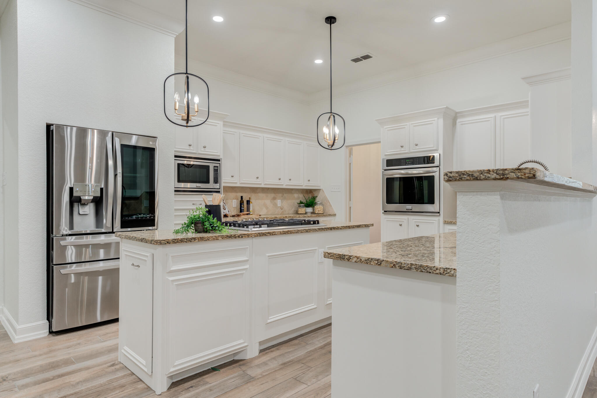 4707 85th Street Lubbock, TX 79424 - Photo 21 of 63 a kitchen with stainless steel appliances a stove a microwave and white cabinets