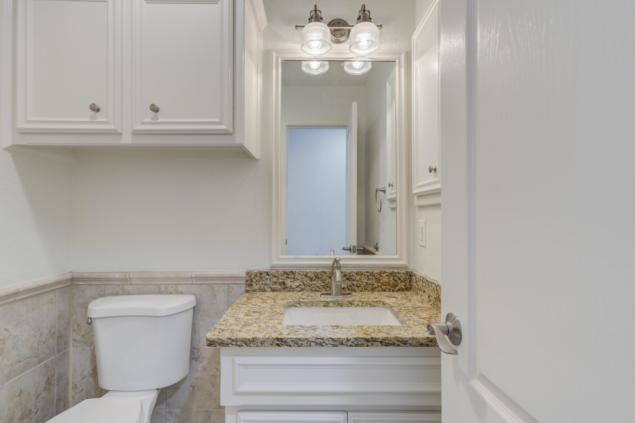 4707 85th Street Lubbock, TX 79424 - Photo 56 of 63 a bathroom with a granite countertop toilet and a sink