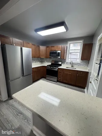 a kitchen with stainless steel appliances a microwave a sink a stove a microwave a refrigerator a sink and cabinets