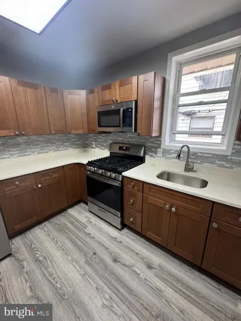 a kitchen with stainless steel appliances granite countertop a sink a stove and cabinets