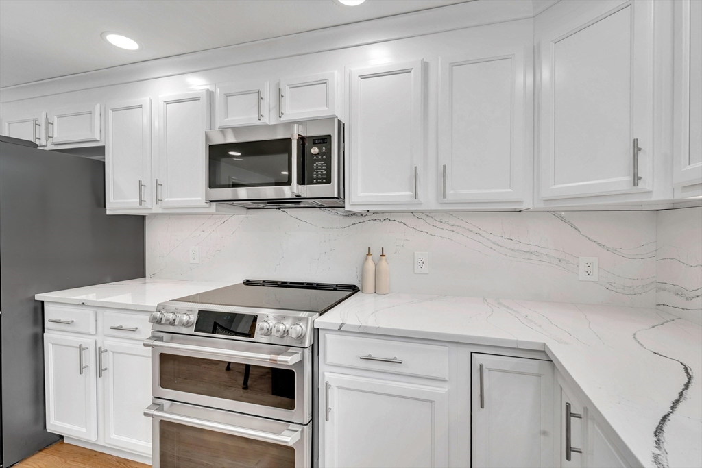 47 Fenwick Circle Methuen, MA 01844 - Photo 13 of 42 a kitchen with stainless steel appliances granite countertop white cabinets and a stove a oven with white countertops