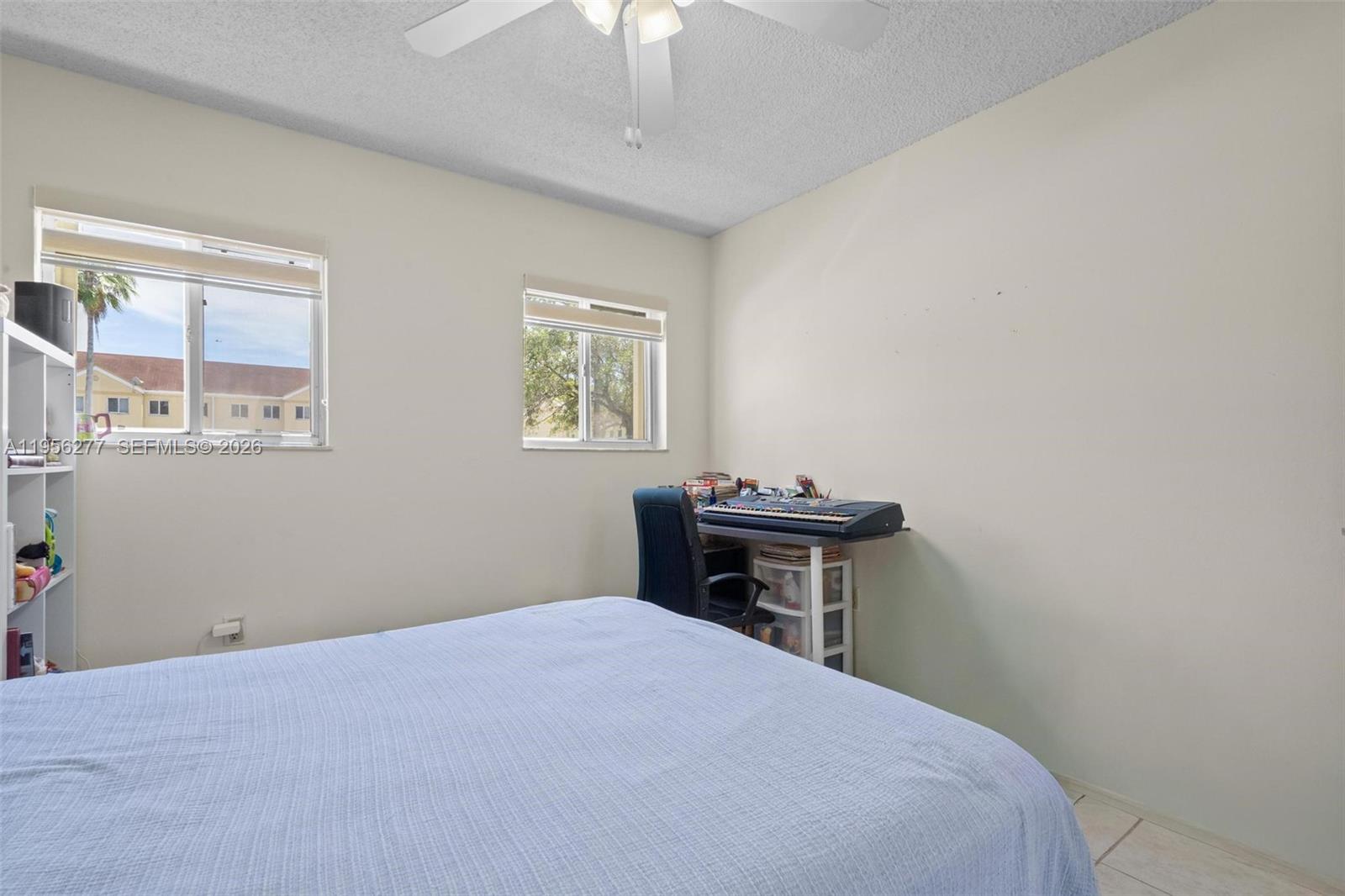 13810 Southwest 112th Street, Unit 102 Miami, FL 33186 - Photo 11 of 28 a bedroom with a bed and a table