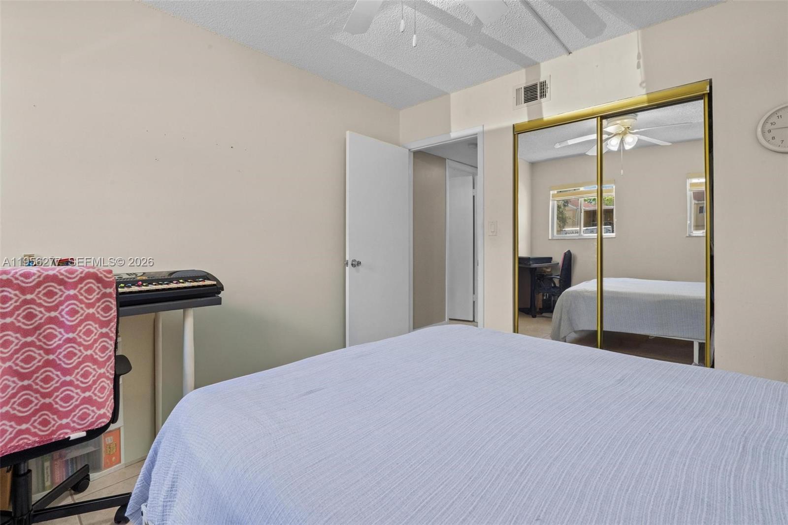 13810 Southwest 112th Street, Unit 102 Miami, FL 33186 - Photo 12 of 28 a bedroom with a bed and a mirror