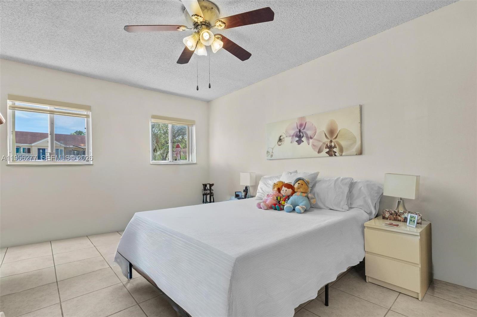 13810 Southwest 112th Street, Unit 102 Miami, FL 33186 - Photo 15 of 28 a bedroom with a bed and a chandelier