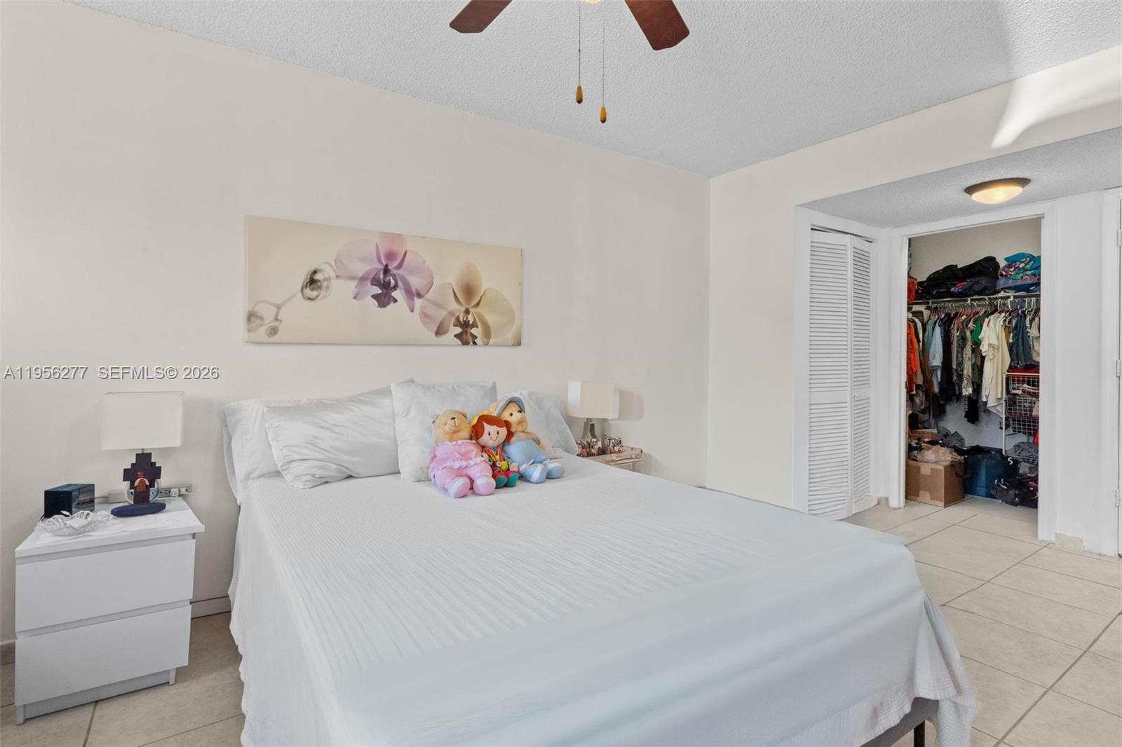13810 Southwest 112th Street, Unit 102 Miami, FL 33186 - Photo 16 of 28 a bedroom with a bed and a large mirror