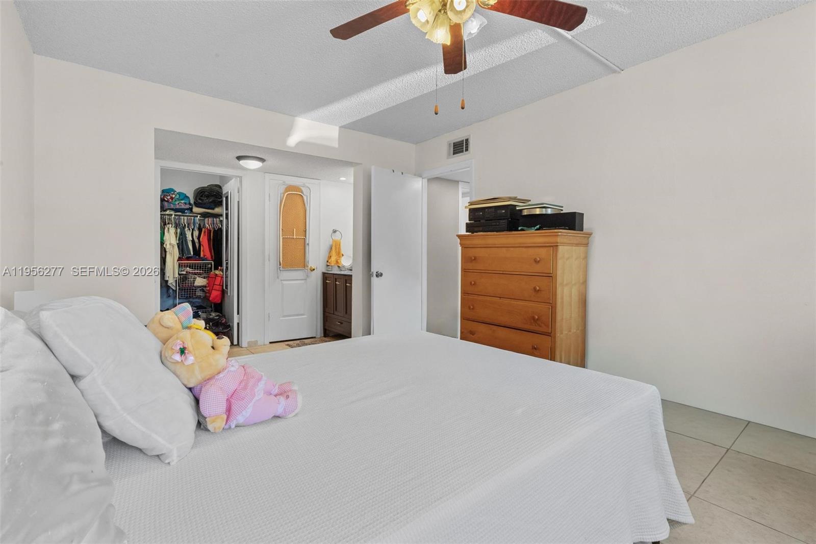 13810 Southwest 112th Street, Unit 102 Miami, FL 33186 - Photo 17 of 28 a bedroom with a bed and a walk in closet