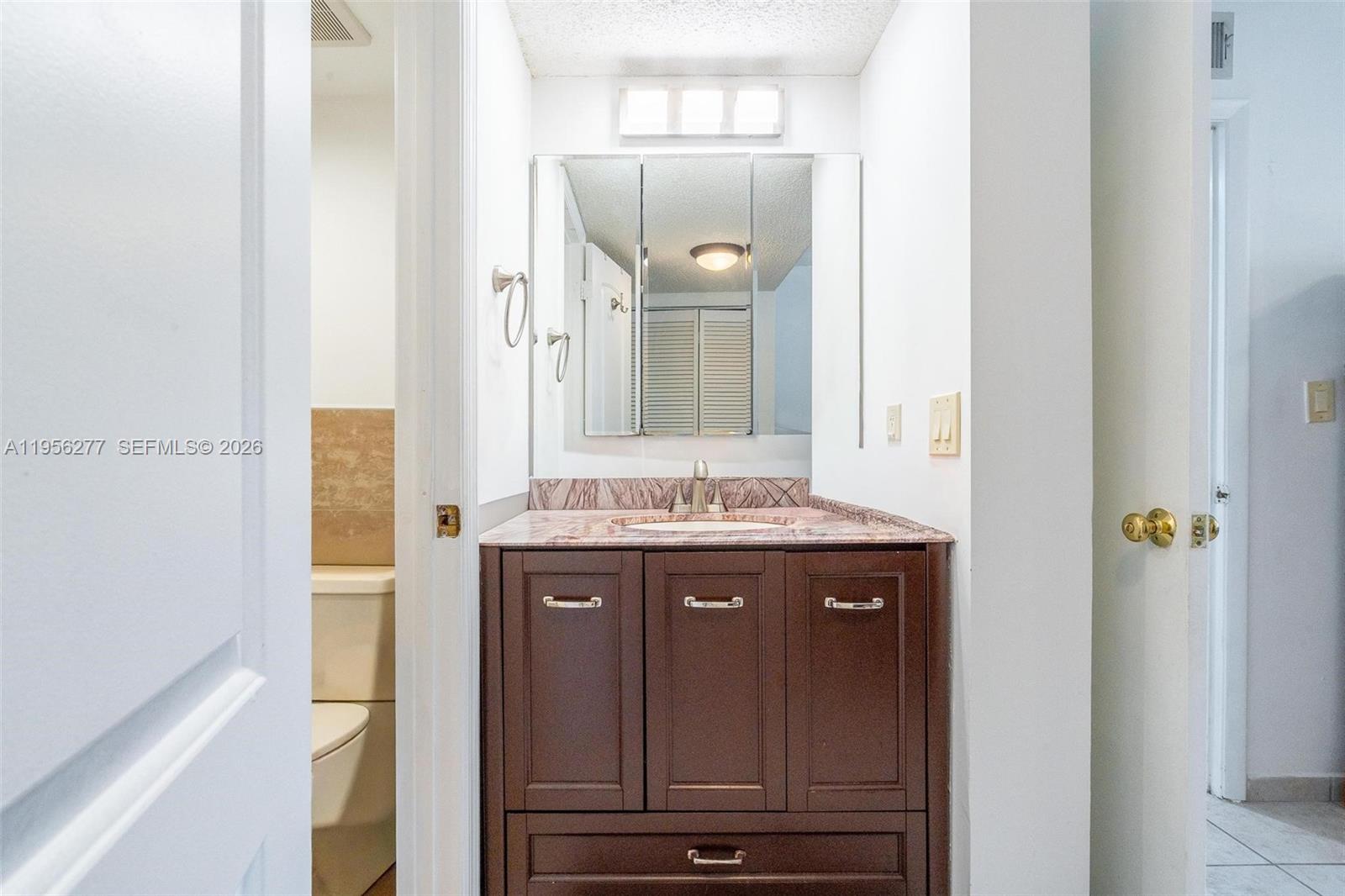 13810 Southwest 112th Street, Unit 102 Miami, FL 33186 - Photo 21 of 28 a view of bathroom with a sink and a mirror