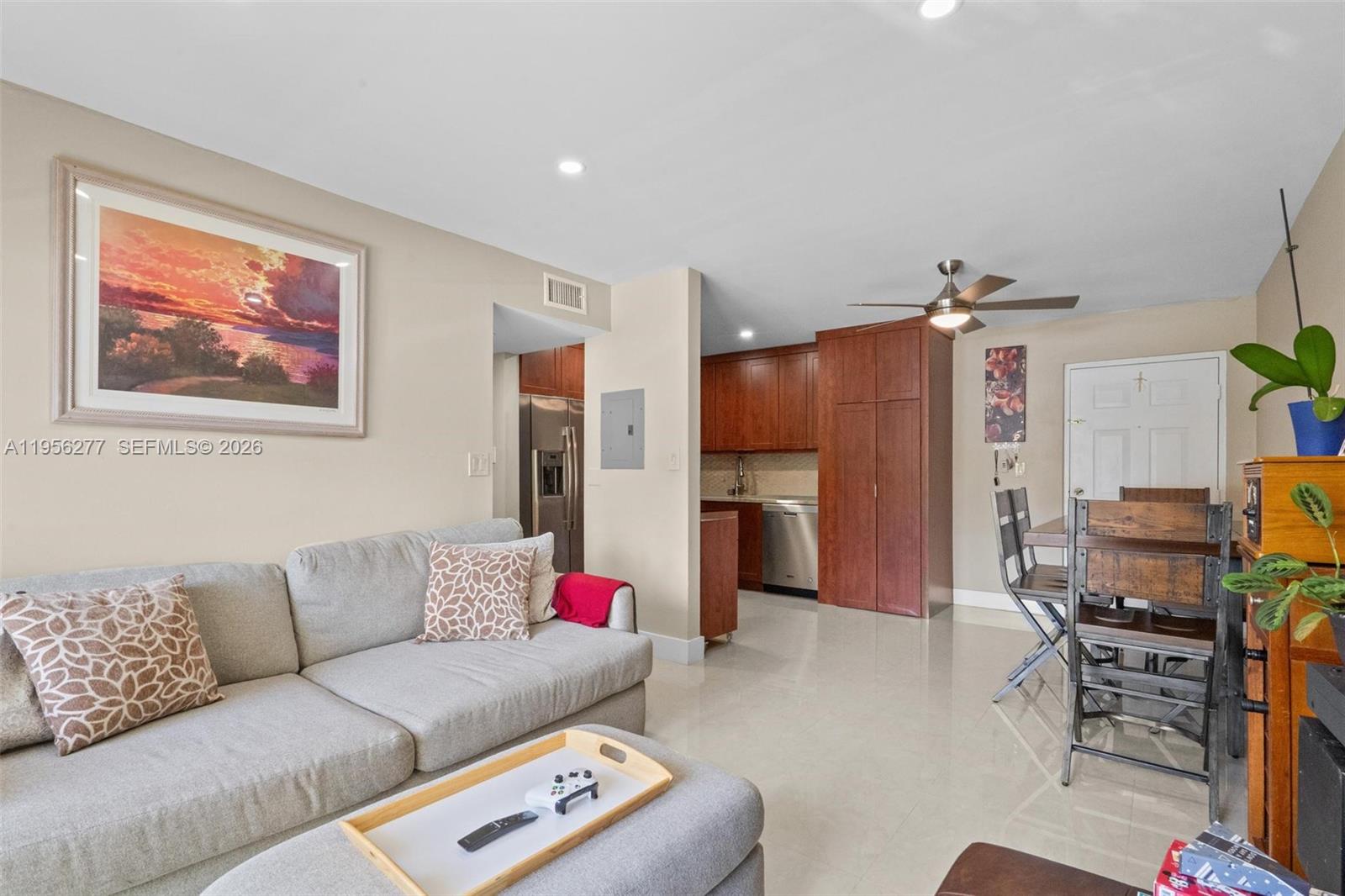13810 Southwest 112th Street, Unit 102 Miami, FL 33186 - Photo 6 of 28 a living room with furniture a chandelier and a dining table
