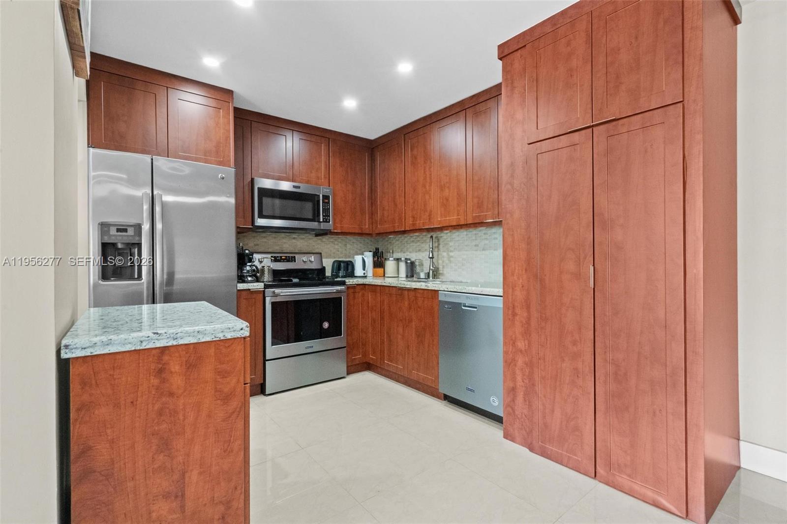13810 Southwest 112th Street, Unit 102 Miami, FL 33186 - Photo 8 of 28 a kitchen with stainless steel appliances granite countertop a refrigerator stove and oven