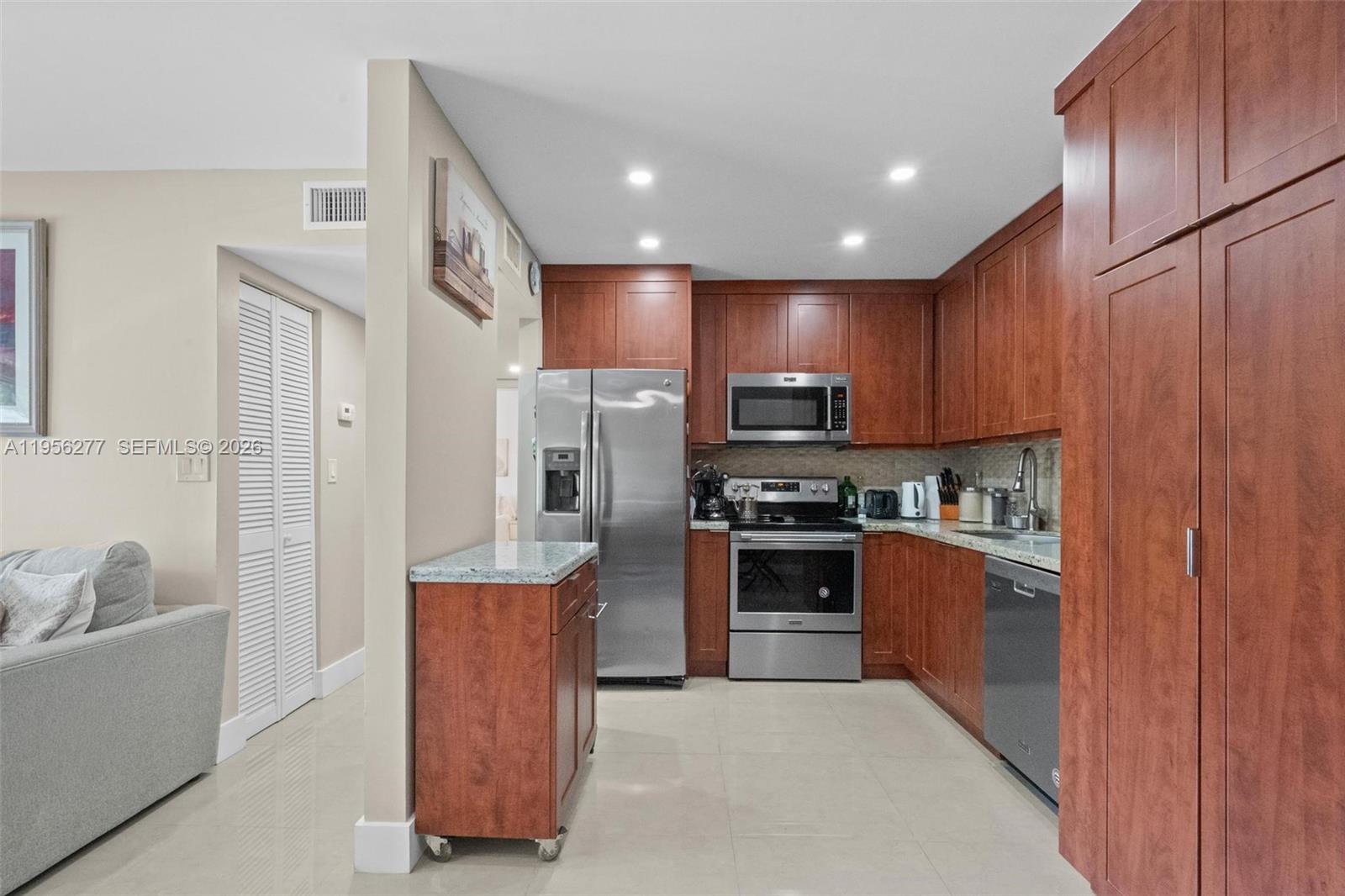 13810 Southwest 112th Street, Unit 102 Miami, FL 33186 - Photo 9 of 28 a kitchen with stainless steel appliances granite countertop a refrigerator stove and sink