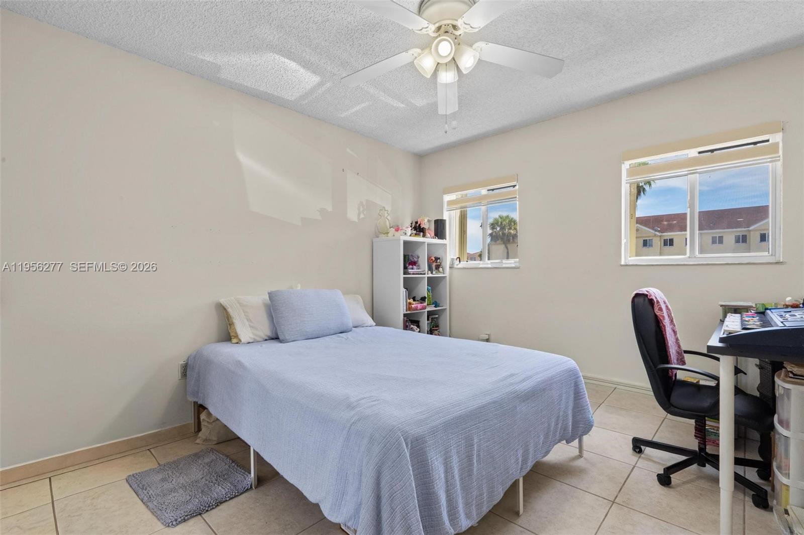 13810 Southwest 112th Street, Unit 102 Miami, FL 33186 - Photo 10 of 28 a bedroom with a bed and a desk