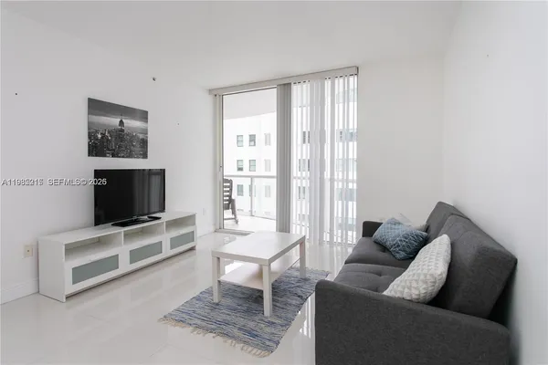 a living room with furniture a flat screen tv and a fireplace