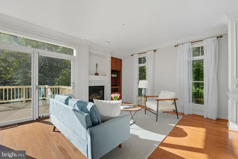 a living room with furniture a large window and a fireplace