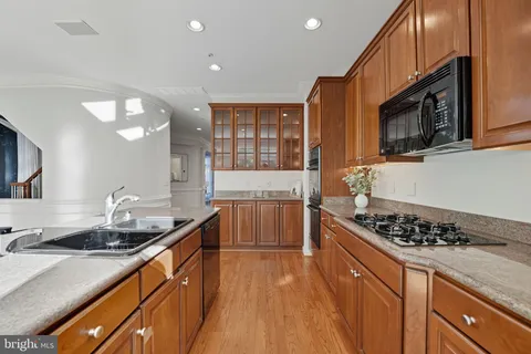 a kitchen with stainless steel appliances kitchen island granite countertop a stove and a sink