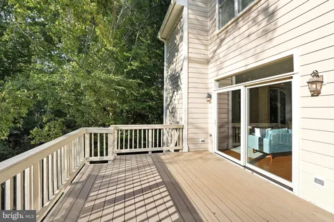 a view of backyard with deck and outdoor seating