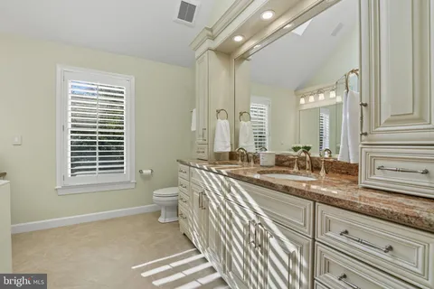 a bathroom with a granite countertop sink a mirror and a shower