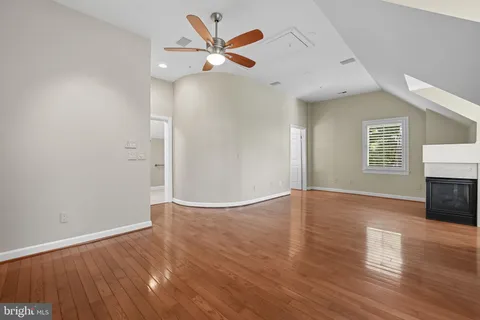 an empty room with wooden floor and fireplace