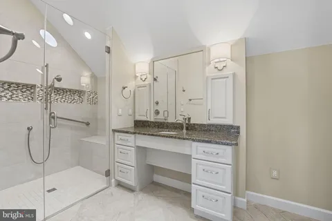 a bathroom with a granite countertop shower mirror and a sink