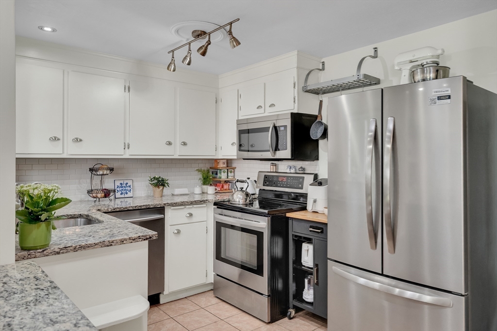 357 Lincoln Street Lexington, MA 02421 - Photo 9 of 29 a kitchen with stainless steel appliances granite countertop a refrigerator sink and stove