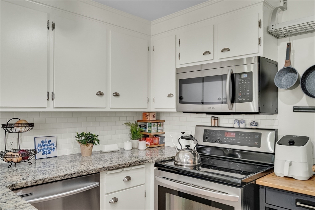 357 Lincoln Street Lexington, MA 02421 - Photo 10 of 29 a kitchen with granite countertop a stove and a microwave