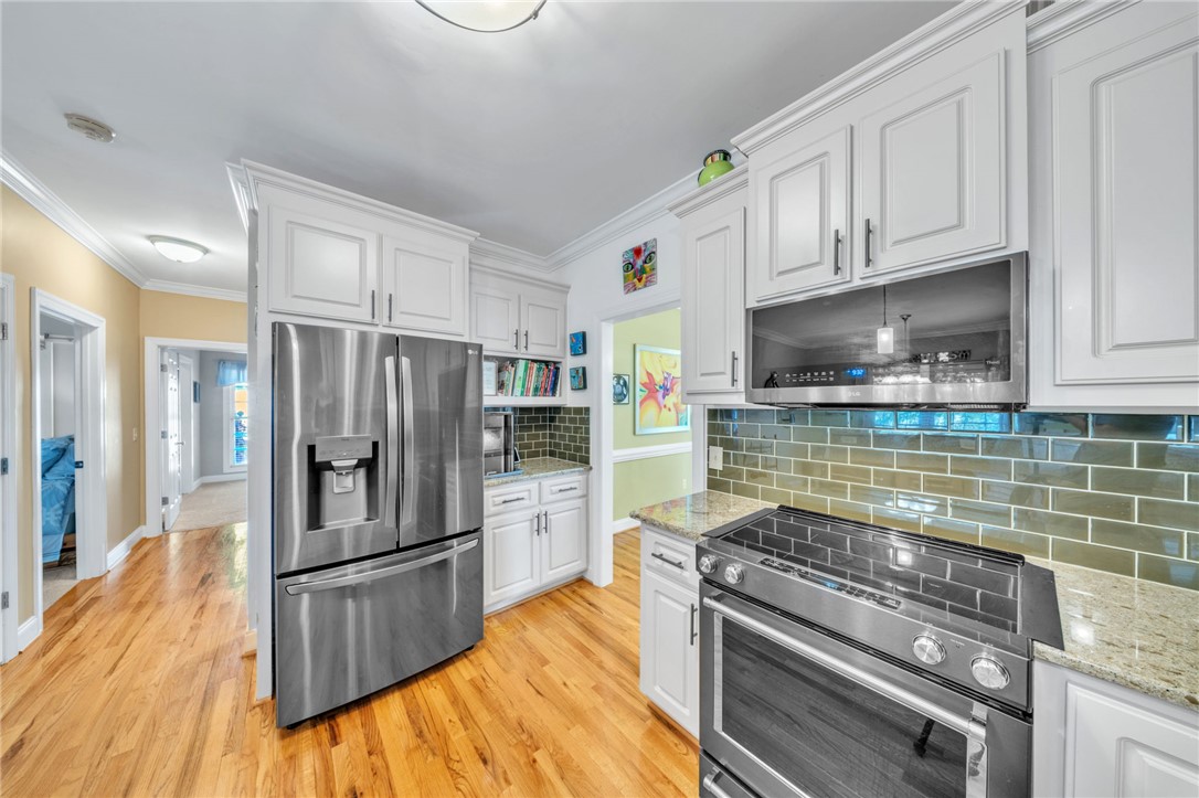 648 Mountain View Road Williamston, SC 29697 - Photo 13 of 42 A chef's kitchen boasts granite counters, gleaming hardwood floors, and stainless steel appliances.