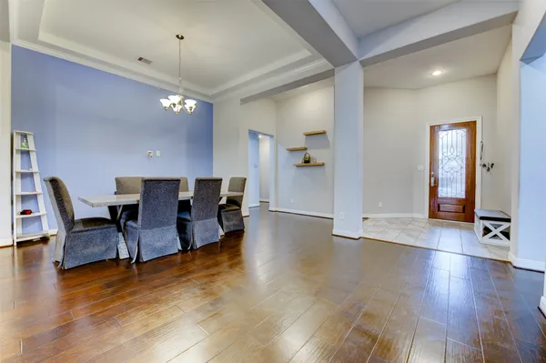 a kitchen with kitchen island granite countertop a stove top oven a sink dishwasher a dining table and chairs with wooden floor