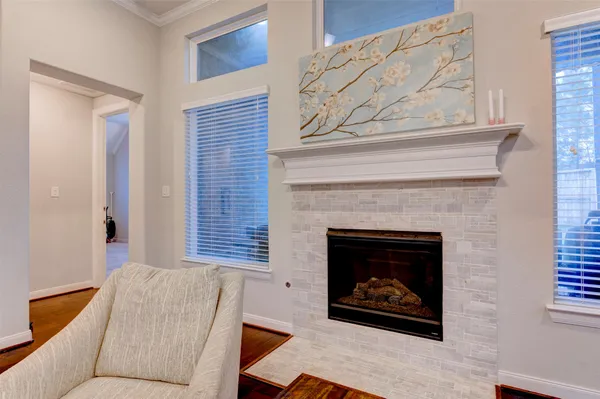 a living room with stainless steel appliances furniture and a wooden floor