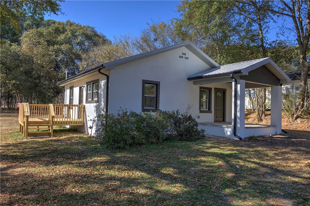 a view of a house with backyard and sitting area