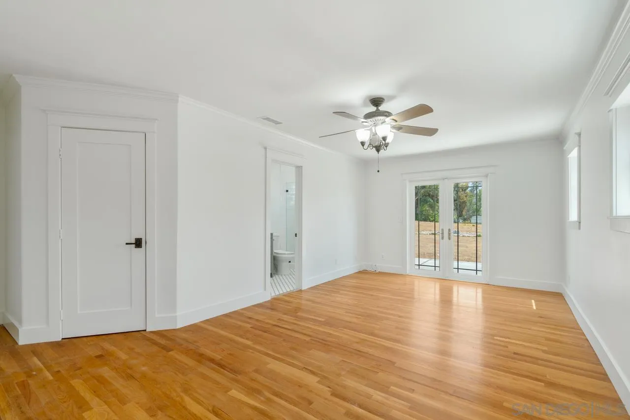 11823 Rocoso Road Lakeside, CA 92040 - Photo 23 of 48 a view of an empty room with chandelier fan and wooden floor