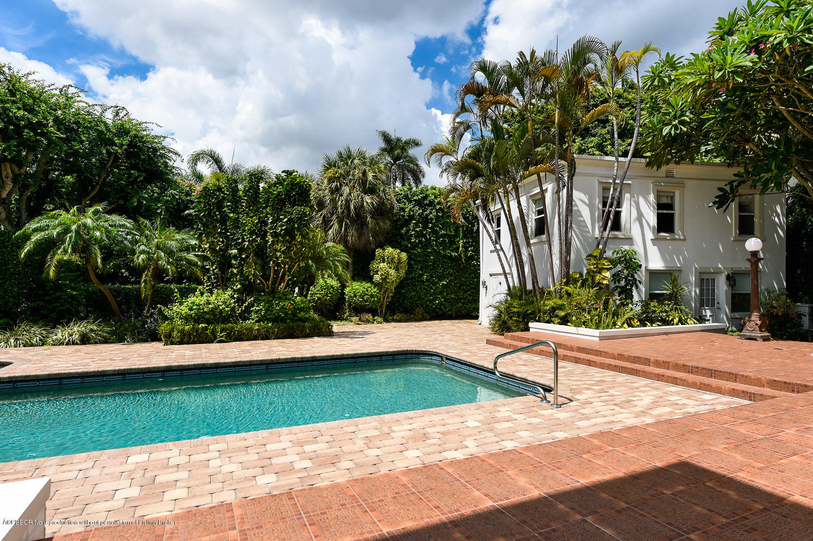 142 South County Road Palm Beach, FL 33480 - Photo 8 of 12 a front view of a house with a yard and potted plants