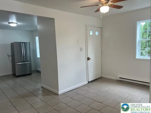 an empty room with fan and windows