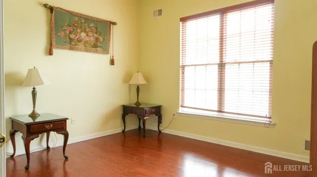 a view of a hallway with wooden floor and a cabinet