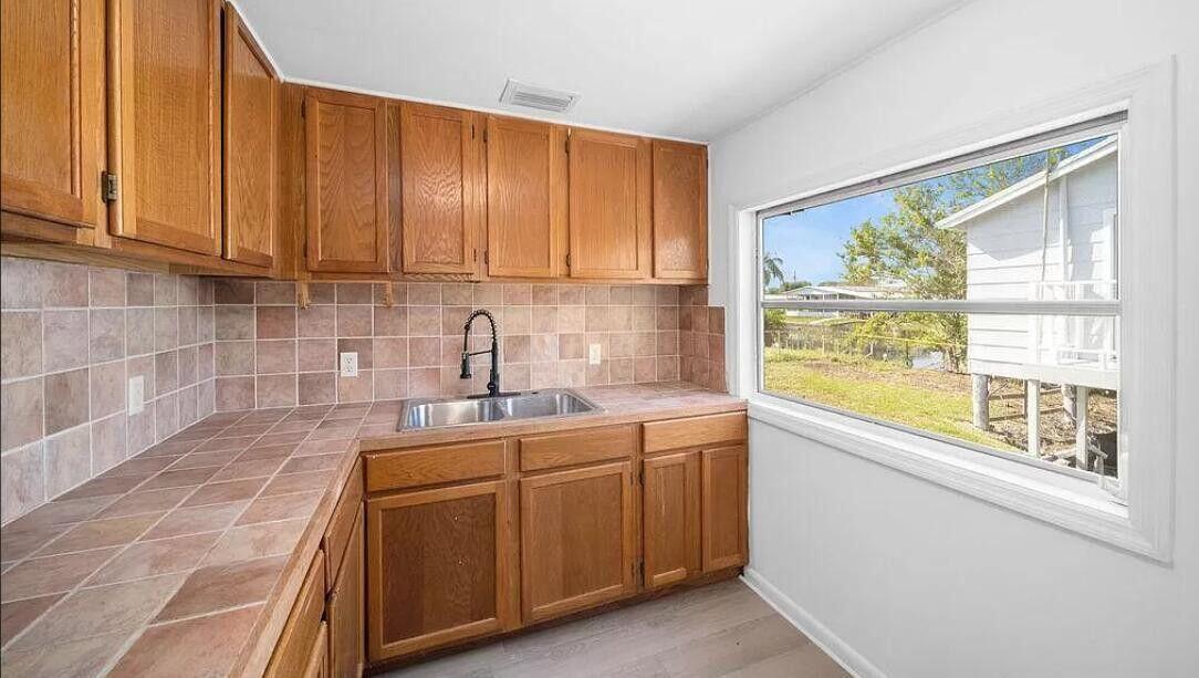 1520 Hunter Road Okeechobee, FL 34974 - Photo 3 of 20 a kitchen with a sink a cabinets and window