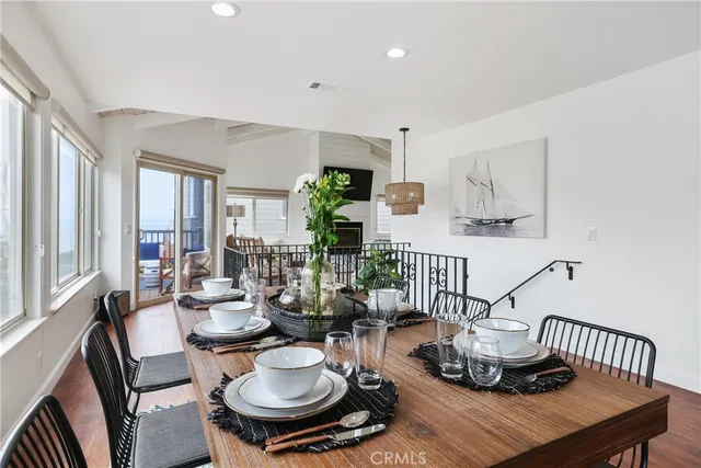 a kitchen with kitchen island granite countertop wooden floor white cabinets and stainless steel appliances