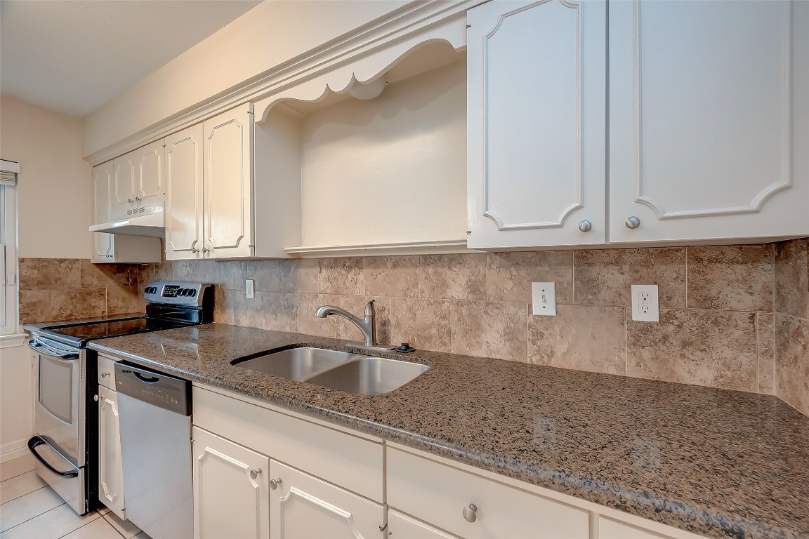 2047 Winrock Boulevard, Unit 61 Houston, TX 77057 - Photo 13 of 50 a kitchen with stainless steel appliances granite countertop a sink a stove and white cabinets