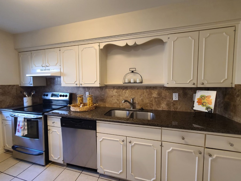 2047 Winrock Boulevard, Unit 61 Houston, TX 77057 - Photo 14 of 50 a kitchen with stainless steel appliances granite countertop a sink a stove and a granite counter tops