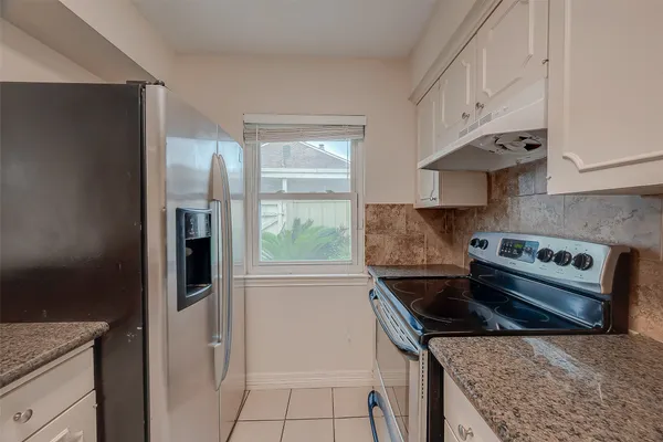 a kitchen with stainless steel appliances granite countertop a refrigerator and a stove