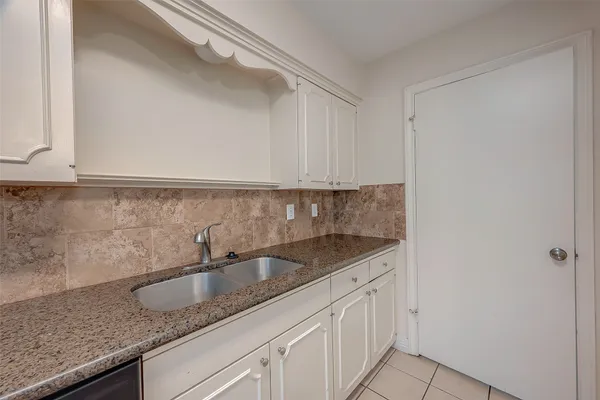 a kitchen with granite countertop a sink and cabinets