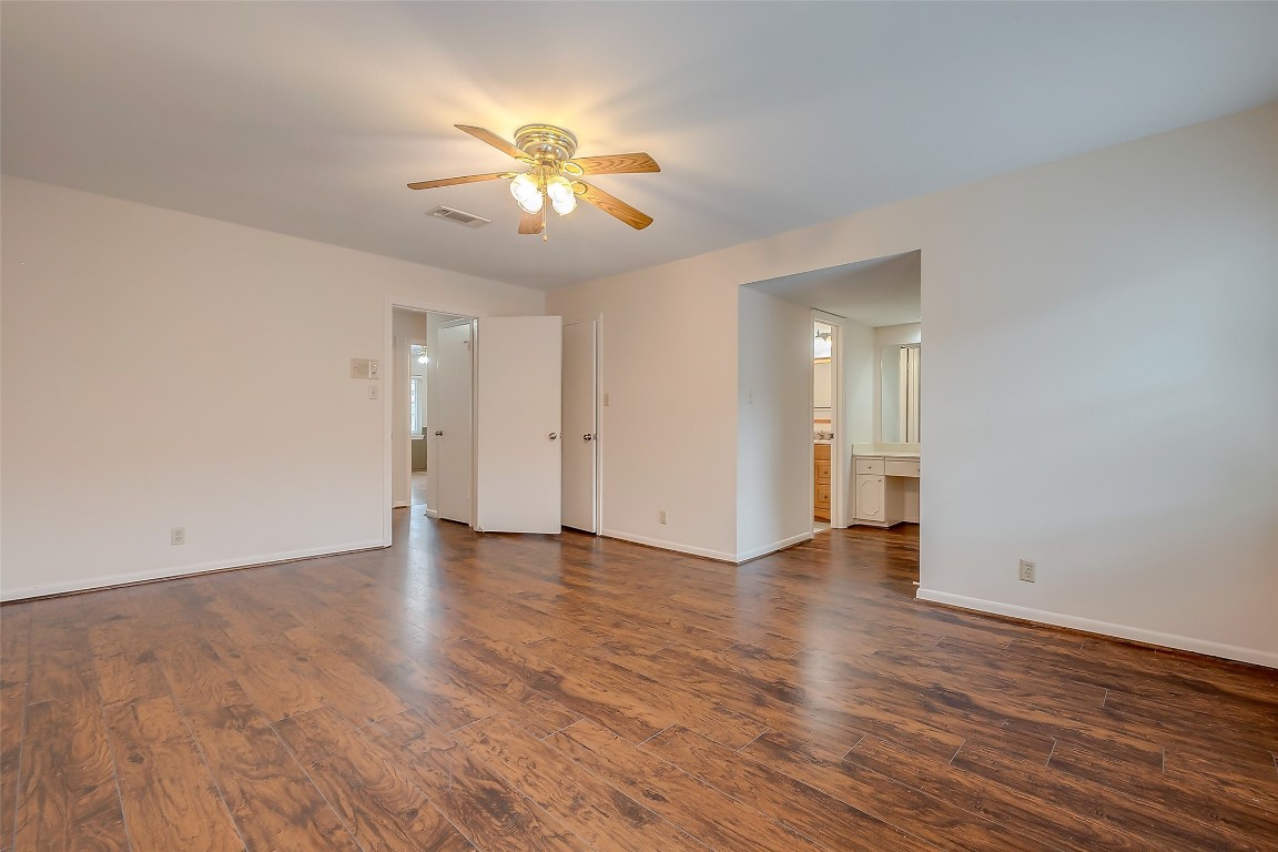 2047 Winrock Boulevard, Unit 61 Houston, TX 77057 - Photo 29 of 50 a view of an empty room with wooden floor and a ceiling fan
