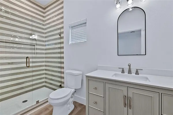 a bathroom with a sink a toilet a mirror and shower curtain
