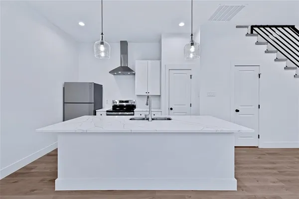 a large white kitchen with a refrigerator a sink dishwasher a stove and a refrigerator