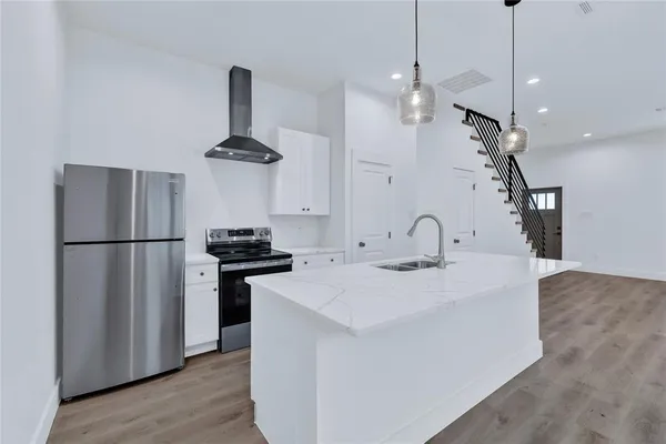 a kitchen with stainless steel appliances granite countertop a sink a stove and a refrigerator