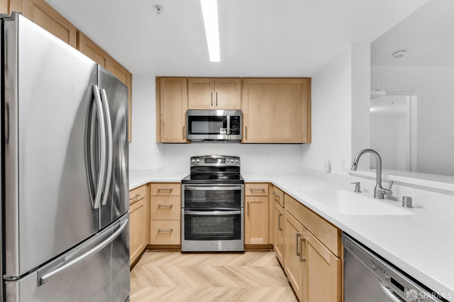 555 10th Street, Unit 102 Oakland, CA 94607 - Photo 11 of 38 a kitchen with granite countertop a refrigerator stove and sink
