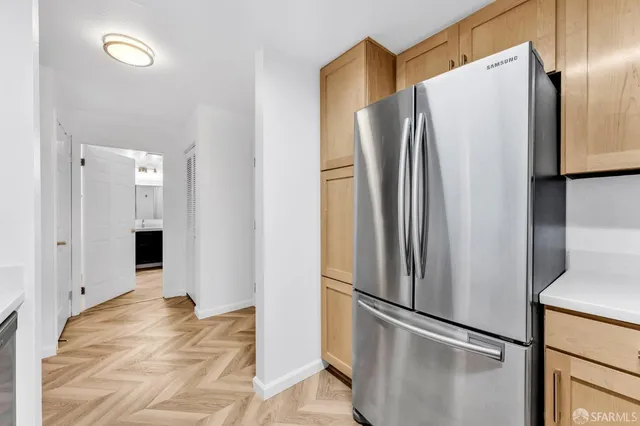 a metallic refrigerator freezer sitting in a kitchen