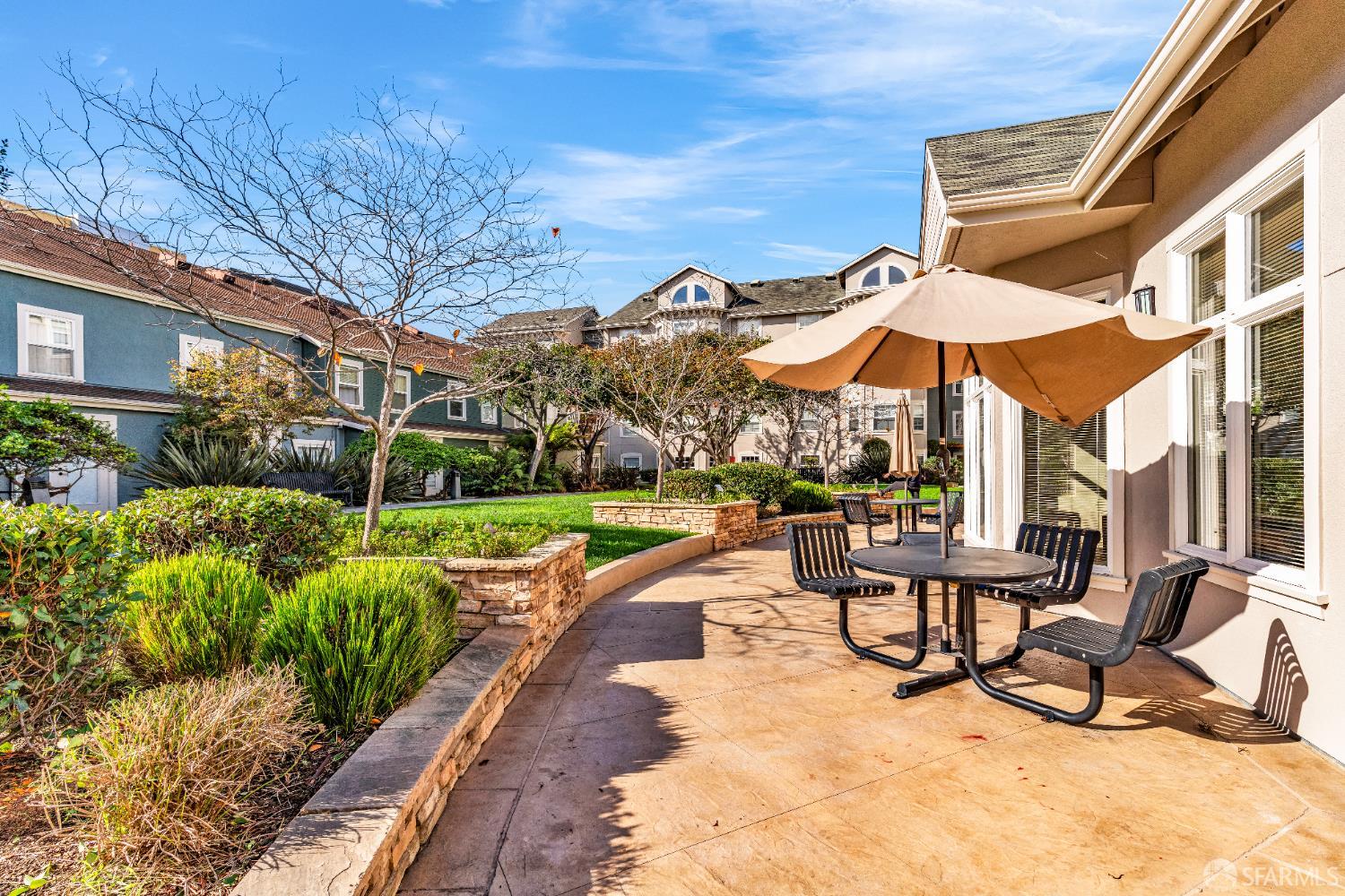 555 10th Street, Unit 102 Oakland, CA 94607 - Photo 2 of 38 a view of a patio with a table and chairs under an umbrella